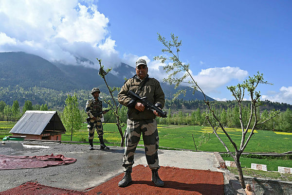 Indian Border Security Force (BSF) soldiers stand guard on the top of a polling station during a second phase of elections at Kangan, some 35 km from Srinagar on April 18, 2019. — AFP