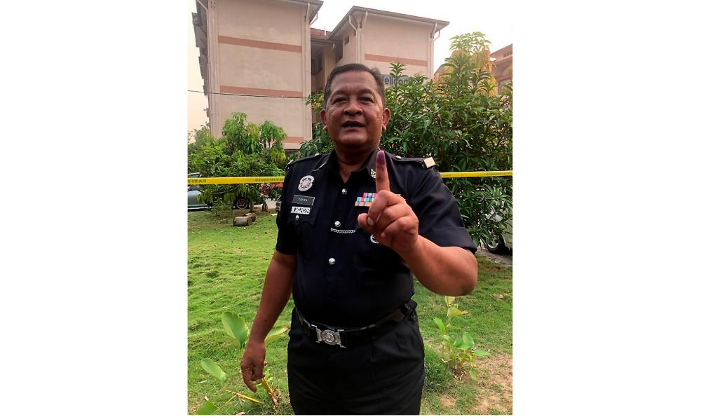 Corporal Yahya Mohd Ariff, 56, showing his finger stained with permanent ink after casting his vote at the early voting centre at the Bangunan Persatuan Keluarga Polis (Perkep) in Pontian District Police Headquarters (IPD) on Nov 12. — Bernama