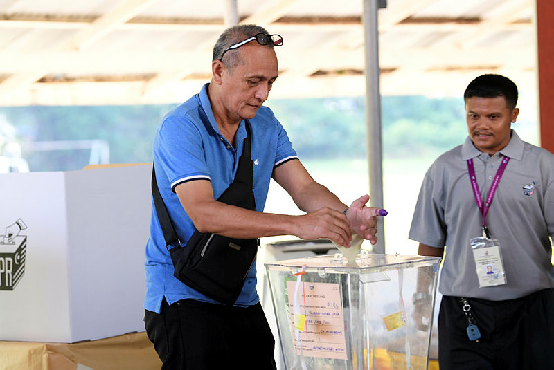 An election officers watches as a voter casts his ballot at SK Muhibbah, on May 11, 2019. — Bernama