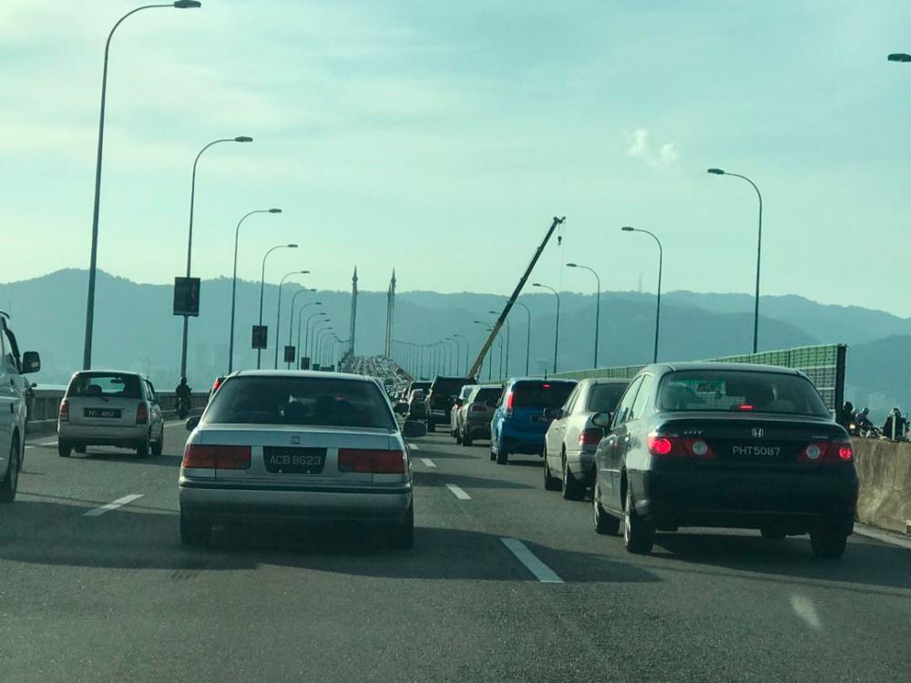 A crane is used in an attempt to retrieve the white SUV which crashed off the Penang Bridge on Jan 19, 2019.