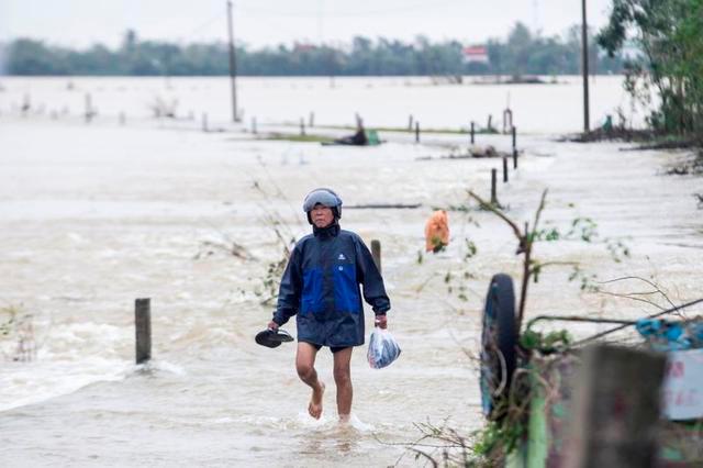 A local resident walks through floodwater to a pickup point for relief packages in Quang An Commune, Thua Thien Hue, Vietnam, October 20, 2020. — Reuters
