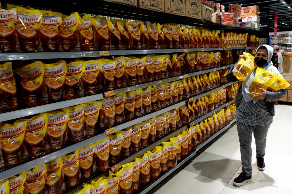 A woman shopping for cooking oil made from oil palm at a supermarket in Jakarta. The Indonesian president says he is reversing the suspension because the domestic supply and price of cooking oil have improved since the ban came into effect. – Reuterspix