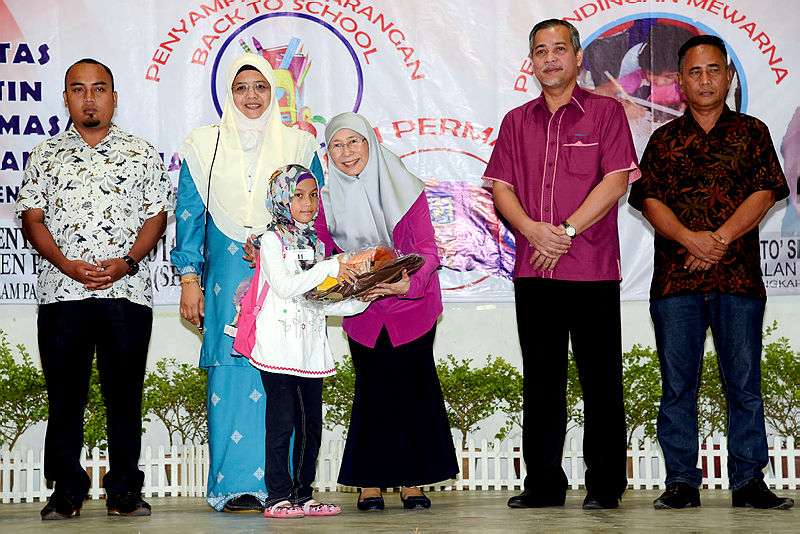 Deputy Prime Minister Datuk Seri Dr Wan Azizah Wan Ismail whis is also PKR Advisory Council chairman, gives aid to a recipient of the ‘Back to School’ programme in Kampung Pandan Dalam, on Dec 29, 2018. — Bernama