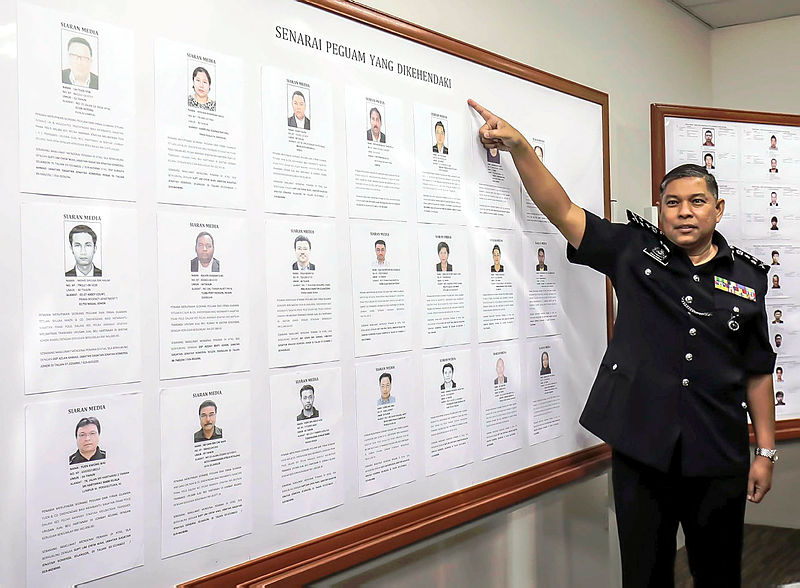 Bukit Aman Commercial Crimes Investigation Department (CCID) director Comm Datuk Seri Mohd Zakaria Ahmad shows the photos of the 21 members of the legal fraternity being sought by police for alleged involvement in 39 criminal breach of trust (CBT) and cheating cases. — Sunpix by Adib Rawi Yahya