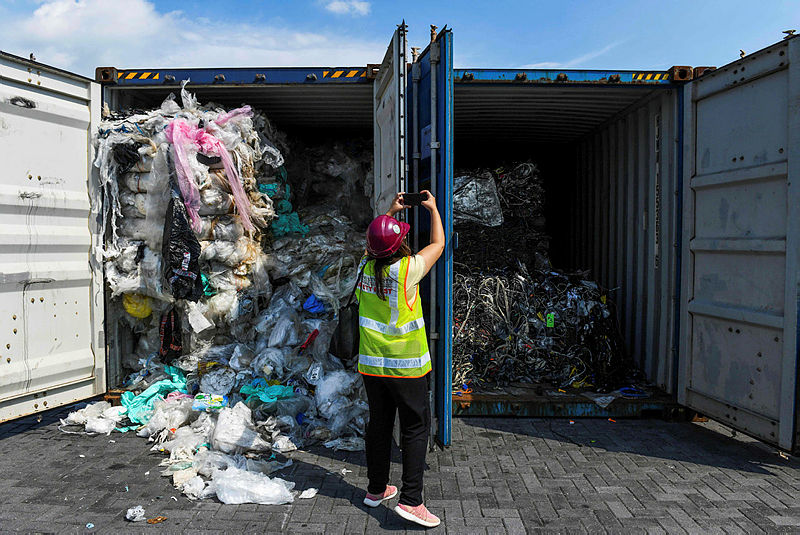 A member of the media takes pictures of containers filled with plastic waste before shipping back to the country of origin in Port Klang, west of Kuala Lumpur on May 28, 2019. — AFP