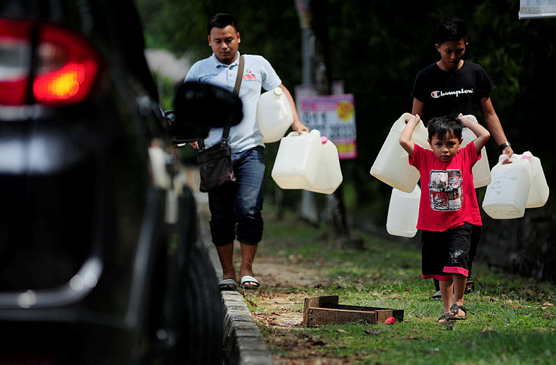 A family in Section 16 Shah Alam head to water tanks to fill up their water drums ahead of the scheduled water disruption from April 24-27. — Bernama