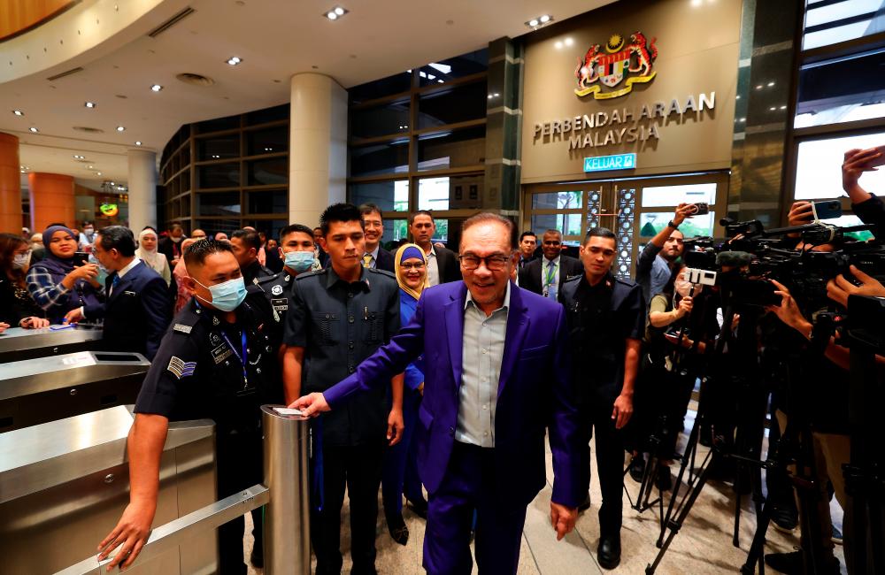Anwar scanning his access card before clocking in as finance minister at the Finance Ministry complex in Putrajaya yesterday. – Bernamapic