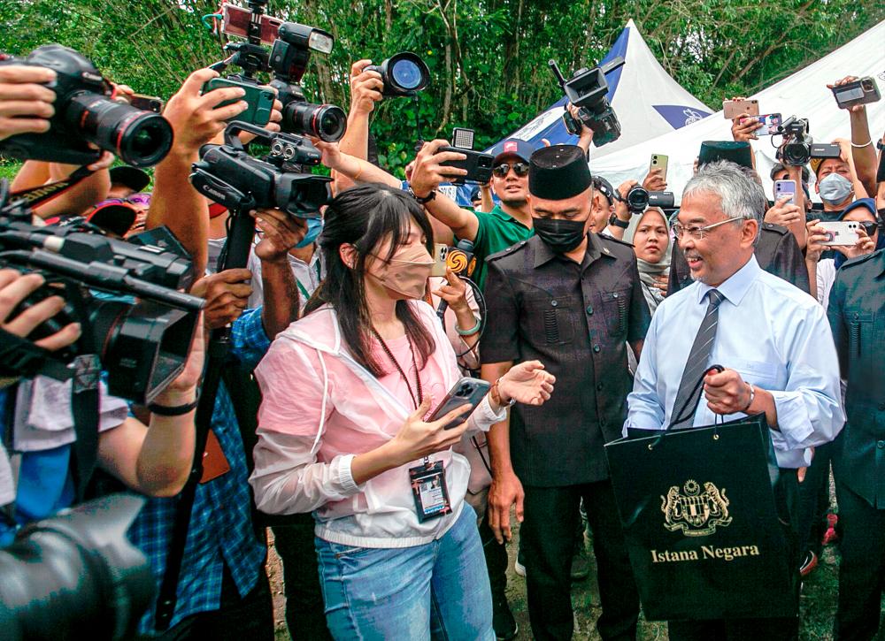 The Yang di-Pertuan Agong handing out food packages to media personnel outside Istana Negara on Monday. – AMIRUL SYAFIQ/THESUN