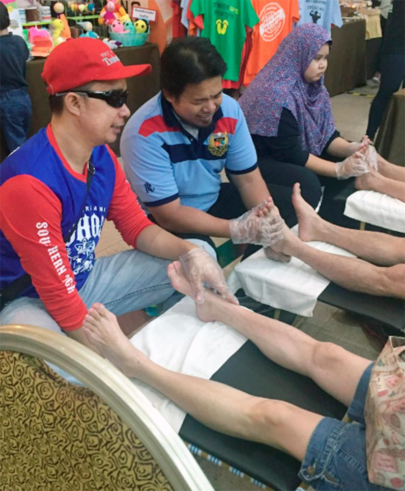 Blind masseurs rendering their services at an event coordinated by Bahoo Massage, which Wan Ahmad intends to expand nationwide.