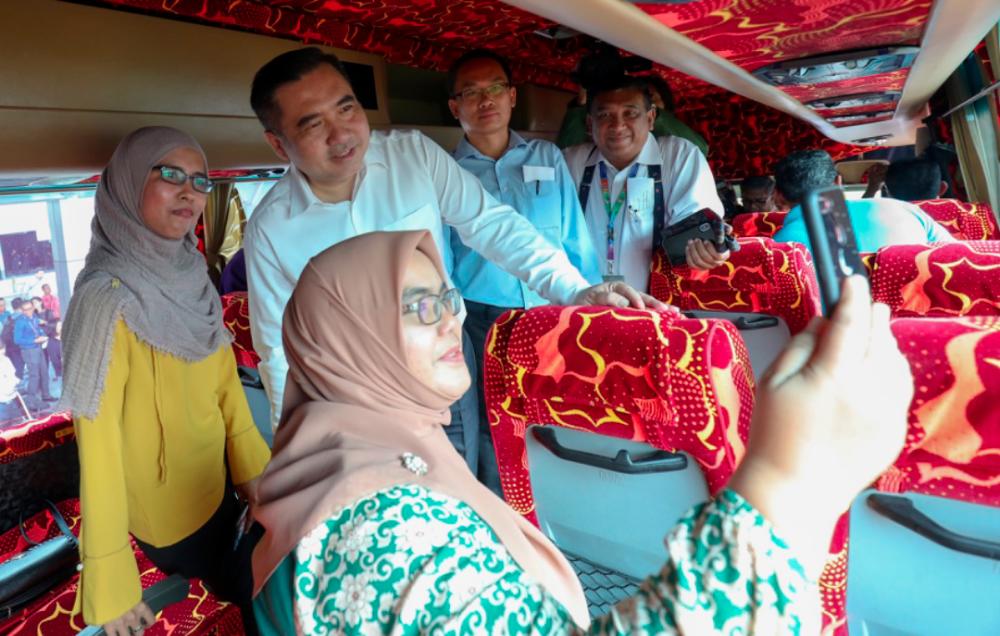 Transport Minister Anthony Loke (L2) mingle with passengers while Prasarana group president Datuk Mohamed Hazlan Mohamed Hussain (R) and Jet Bus general manager Lee Hock Tiam (R2) looks on after the launch of the shuttle bus service from LRT Putra Heights to KLIA on March 7, 2019. — Sunpix by Asyraf Rasid