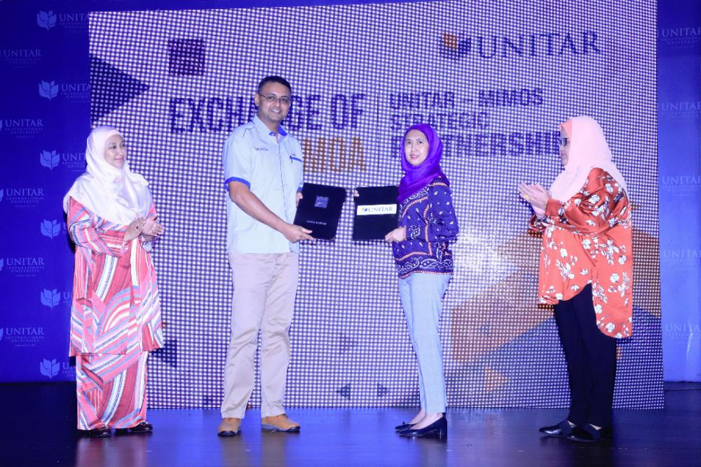 Mimos CEO Emelia Matrahah (3rd from L) and Unitar CEO Puvan Balachandran exchange documents after signing the MoU.