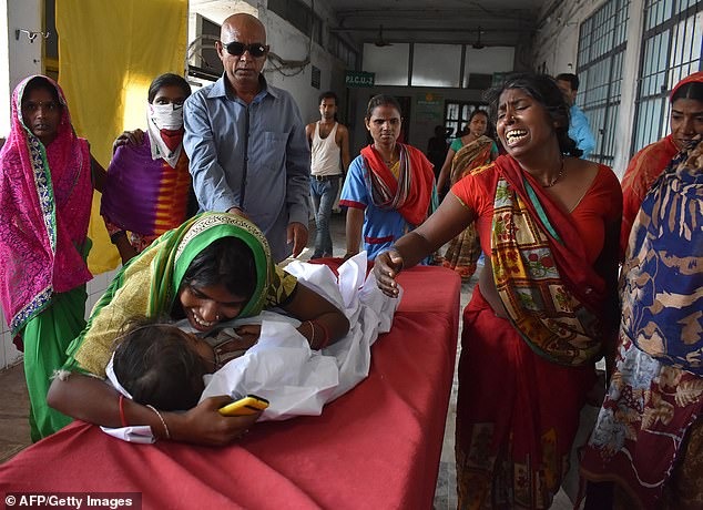 An Indian child arrives in a hospital due to Acute Encephalitis Syndrome as family members weep in Muzaffarpur, Bihar last week. — AFP