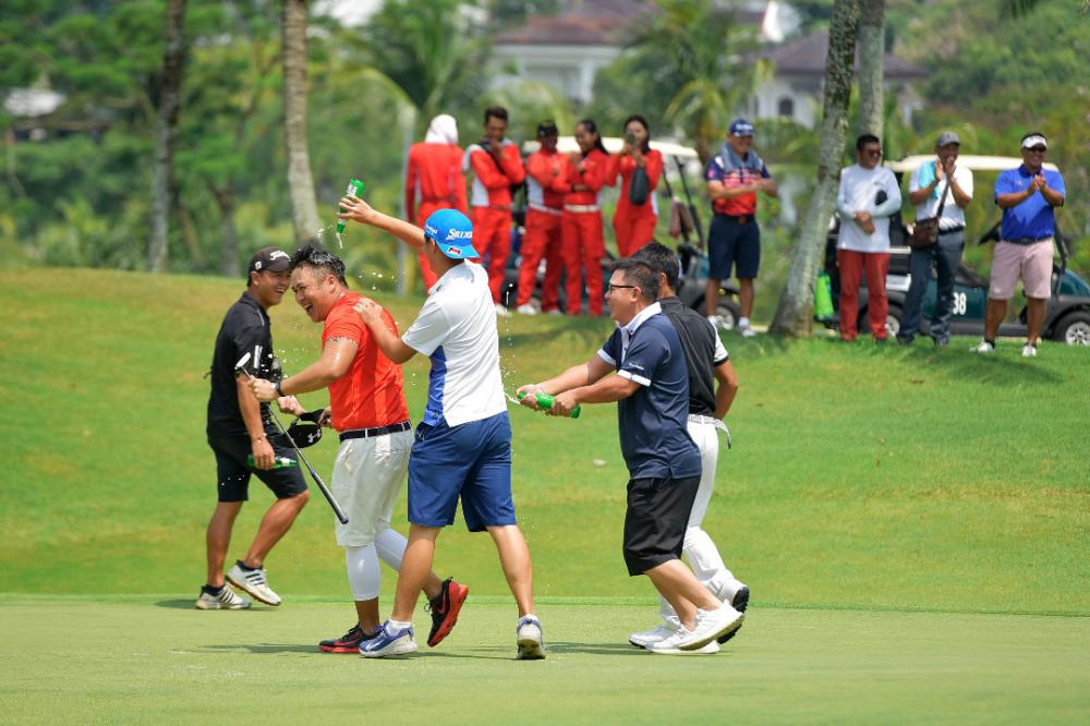 Friends spray Men’s champion Wong Jie Hau with drinks after his final hole.