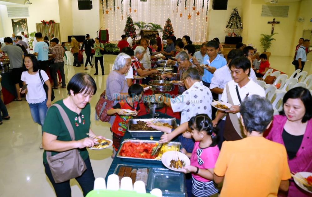 Members of the public queue for food at the buffet line. — Borneo Post