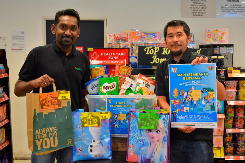 Marketing General Manager of 7-Eleven Malaysia Ronan Lee (R) and General Manager of Operations Christopher Anthony make a contribution to the ‘Lend a Helping Hand Campaign 2020’.