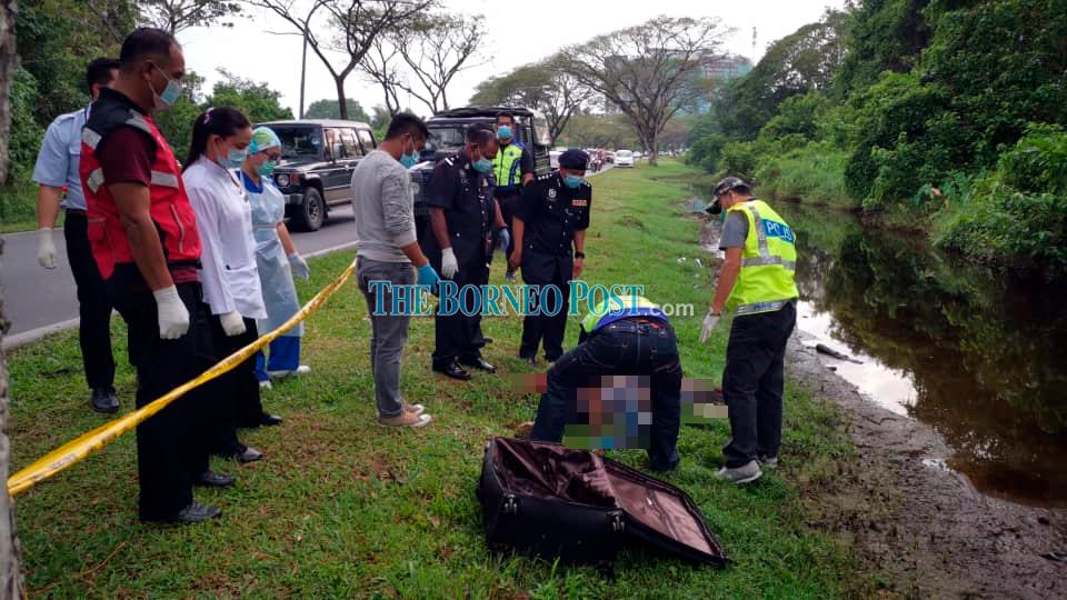 Police personnel examining the body at the scene.