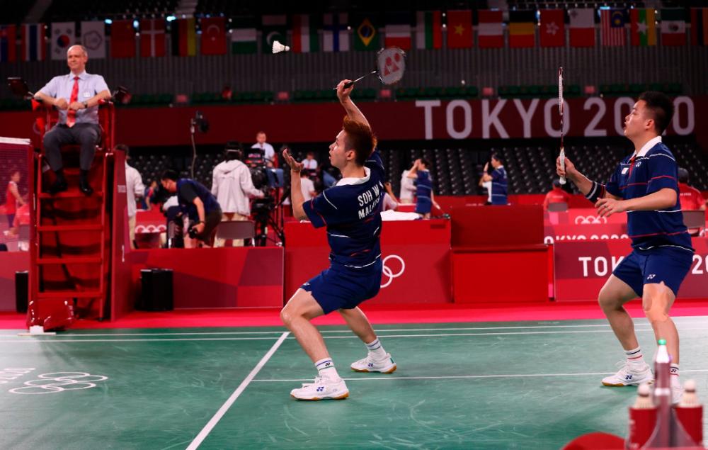Soh Wooi Yik of Malaysia in action near Aaron Chia of Malaysia during the match against Jason Ho-Shue of Canada and Nyl Yakura of Canada. — Reuters