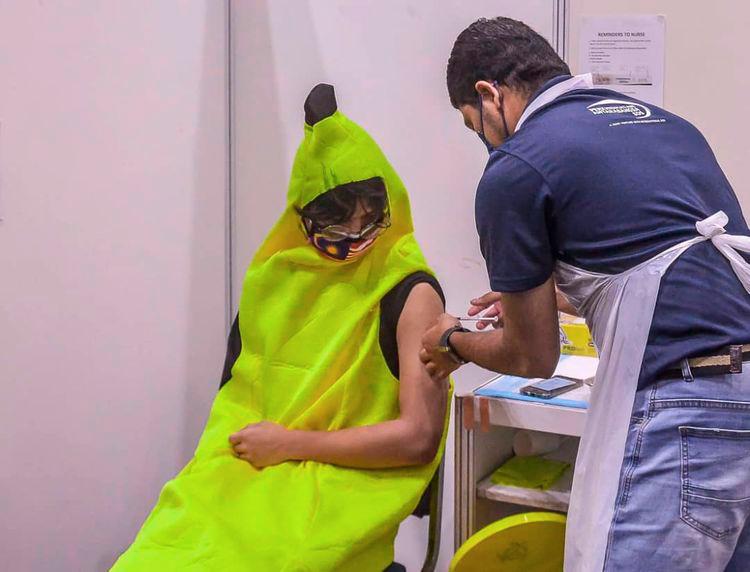 $!EYE-CATCHING ... Donning a banana costume, walk-in vaccine recipient Tengku Ian Mayudin Tengku Harriz Nazlie, 18 makes heads turn and livens up the otherwise cheerless atmosphera at the KLCC Covid-19 vaccination centre in Kuala Lumpur. - ADIB RAWI YAHYA/THESUN.