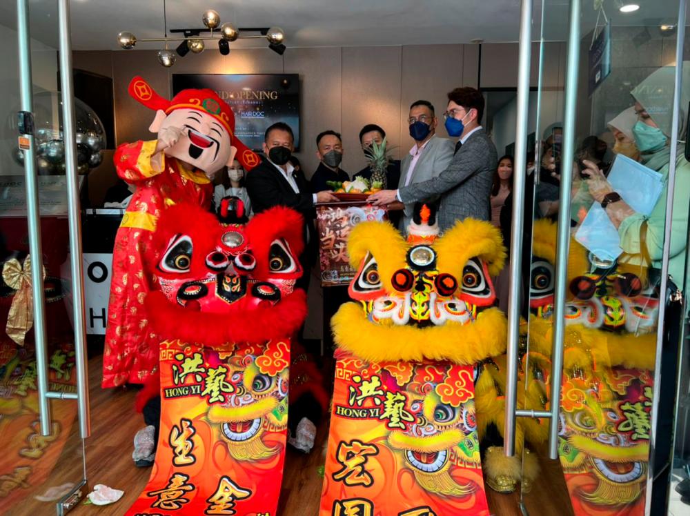 An extra special day ... Dato’ Sri Alexander posing for photos with the founders, special guests and lion dance troupe during the opening ceremony.
