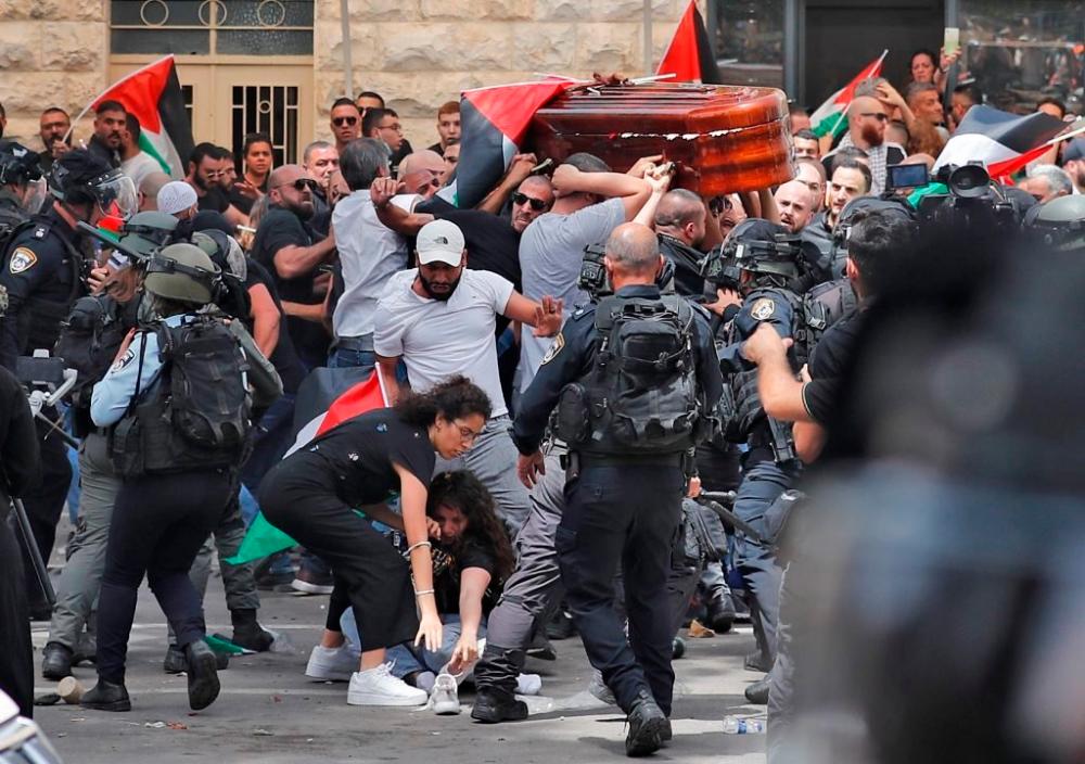 Violence erupts between Israeli security forces and Palestinian mourners carrying the casket of slain Al Jazeera journalist Shireen Abu Akle out of a hospital, before being transported to a church and then her resting place, in Jerusalem, on May 13/AFPPix