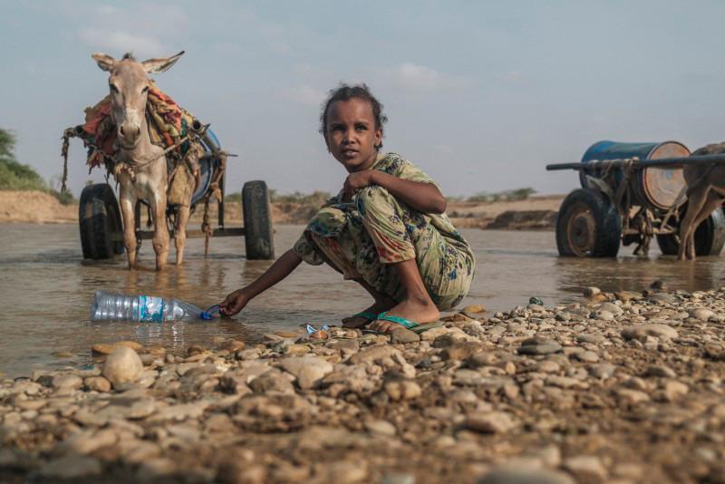 A girl collects water with a bottle in the Shabelle River in the city of Gode, Ethiopia, on April 8. The worst drought to hit the Horn of Africa for 40 years is pushing 20 million people towards starvation, according to the UN, destroying an age-old way of life and leaving many children suffering from severe malnutrition as it rips families apart/AFPPix