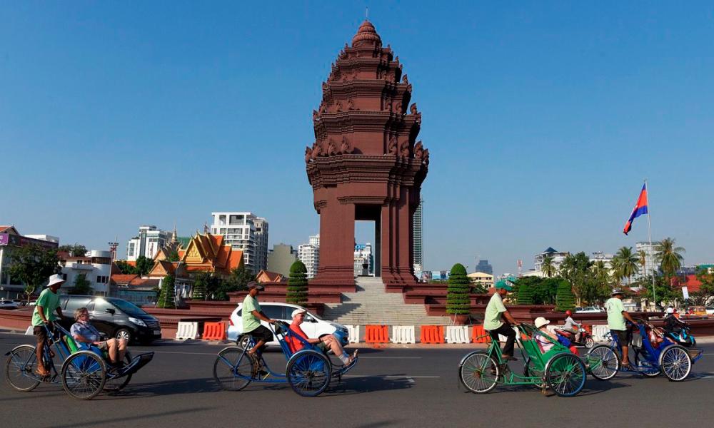 $!Tourists ride on cyclos pass the Independence Monument in Phnom Penh. –AFP