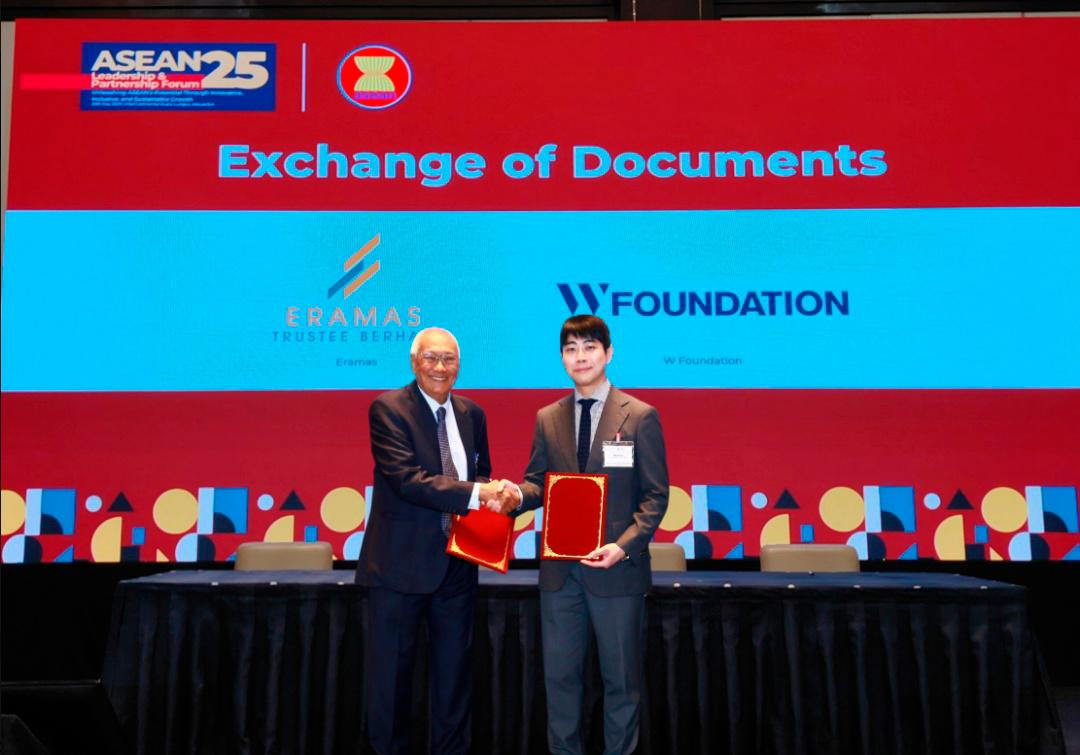 (From left to right): Zaki Azmi and Wook Lee exchanging documents.