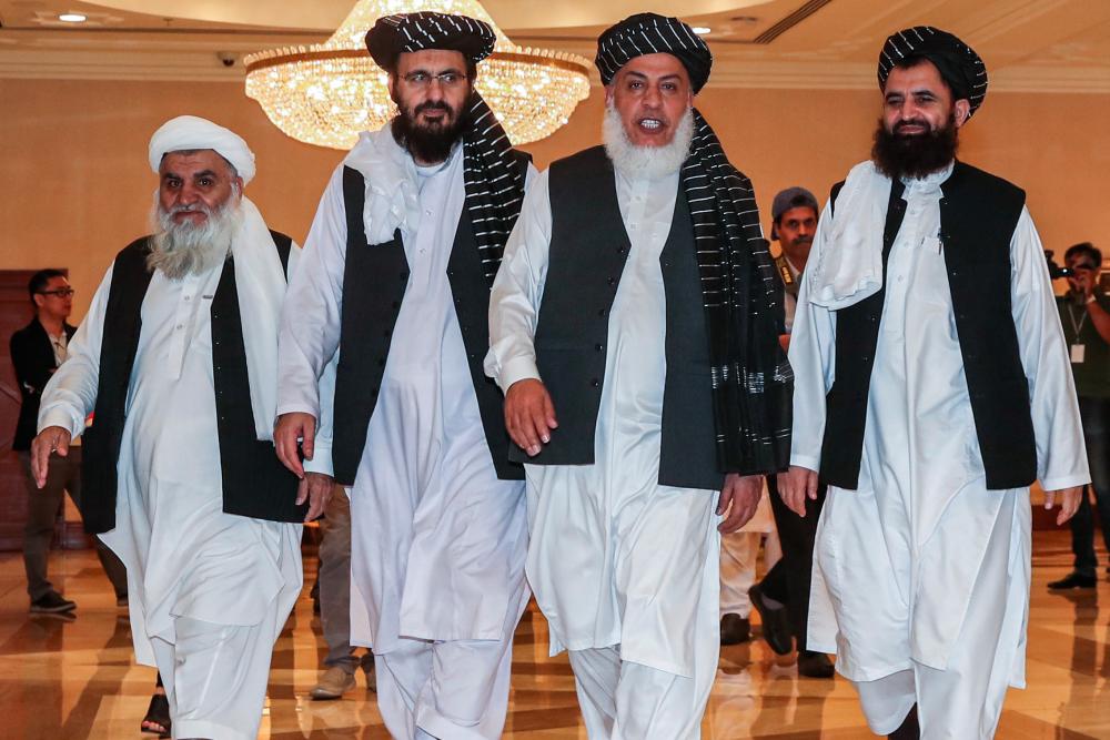 In this file photo taken on July 8, 2019, Mohammad Nabi Omari (C-L), a Taliban member formerly held by the US at Guantanamo Bay and reportedly released in 2014 in a prisoner exchange, Taliban negotiator Abbas Stanikzai (C-R), and former Taliban intelligence deputy Mawlawi Abdul Haq Wasiq (R) walk with another Taliban member during the second day of the Intra Afghan Dialogue talks in the Qatari capital Doha. - AFP
