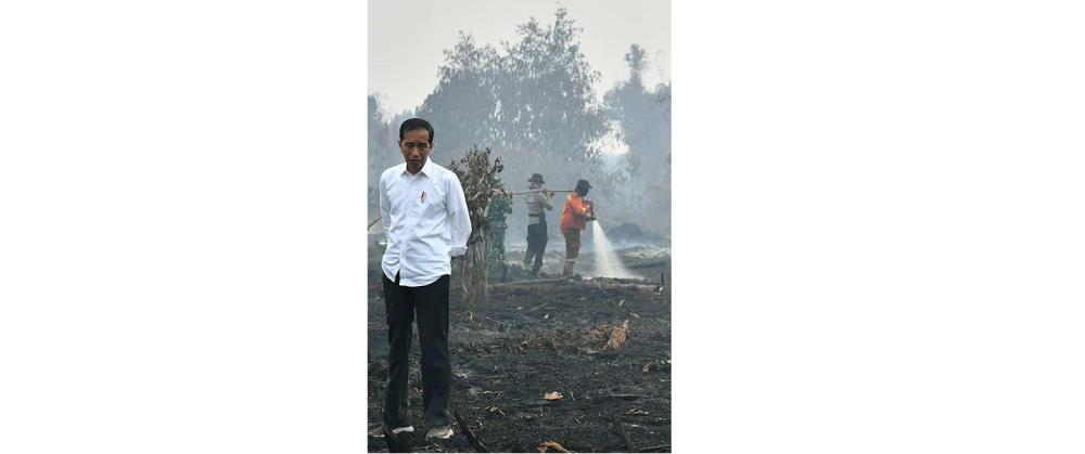 This handout picture taken on September 17, 2019 shows Indonesian President Joko Widodo inspecting the damages from the ongoing forest fires in Pekanbaru. — AFP