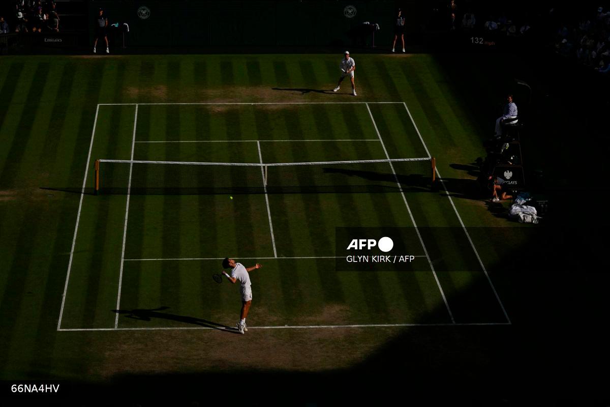 Spain's Carlos Alcaraz serves to Italy's Jannik Sinner during their men's singles final tennis match on the fourteenth day of the 2025 Wimbledon Championships at The All England Lawn Tennis and Croquet Club in Wimbledon, southwest London, on July 13, 2025. - Glyn KIRK / AFP