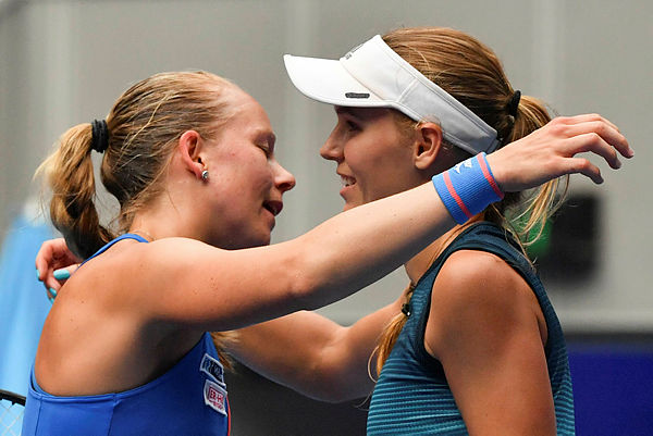 Denmark’s Caroline Wozniacki (R) hugs Sweden’s Johanna Larsson after winning their women’s singles match on day three of the Australian Open tennis tournament — AFP