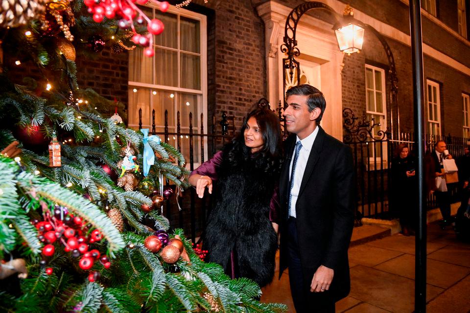 British Prime Minister Rishi Sunak and his wife Akshata Murty look at a Christmas tree after visiting a food and drinks market promoting British small businesses over the festive season, on Downing Street in London, Britain, November 30, 2022. REUTERSPIX