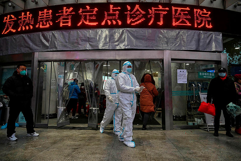 Medical staff members wearing protective clothing to help stop the spread of a deadly virus which began in the city, walk at the Wuhan Red Cross Hospital in Wuhan on Jan 25, 2020.