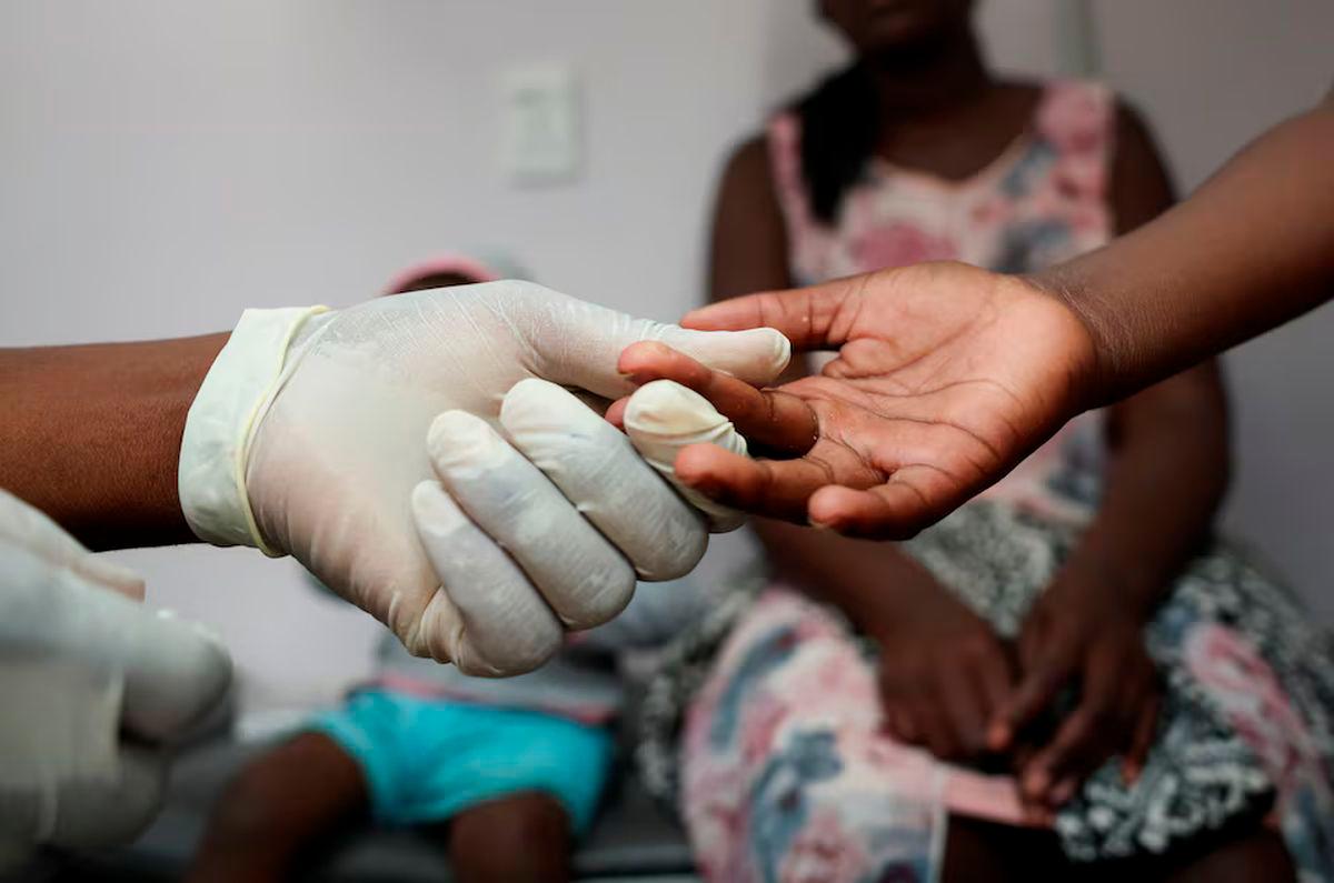 A nurse takes a blood sample from a child for an HIV test while the child’s mother looks on at a clinic in Diepsloot, north of Johannesburg, South Africa, March 12, 2025. REUTERS/Siphiwe Sibeko