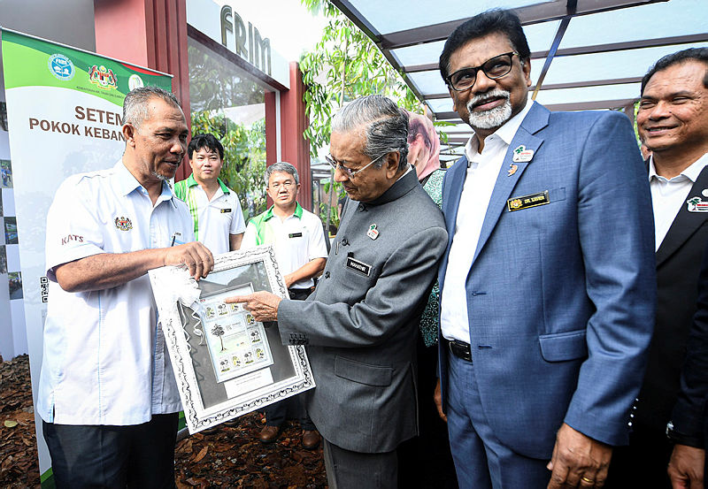 From left: FRIM director-general Datuk Dr Abd Latif Mohmod, presents a souvenir to Prime Minister Mohamad as Water, Land and Natural Resources Minister Dr Xavier Jayakumar (R) looks on, during the Hutan Kita exhibition at KL Tower, on Aug 23, 2019. — Bernama