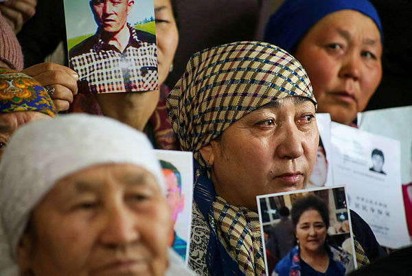 Petitioners with relatives missing or detained in Xinjiang hold up photos of their loved ones during a press event at the office of the Ata Jurt rights group in Almaty — AFP