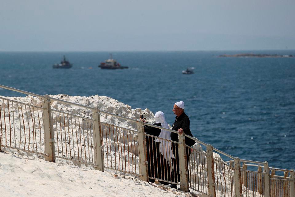 People walk as Israeli navy boats are seen in the Mediterranean Sea as seen from Rosh Hanikra, close to the Lebanese border, northern Israel May 4, 2021. REUTERSPIX