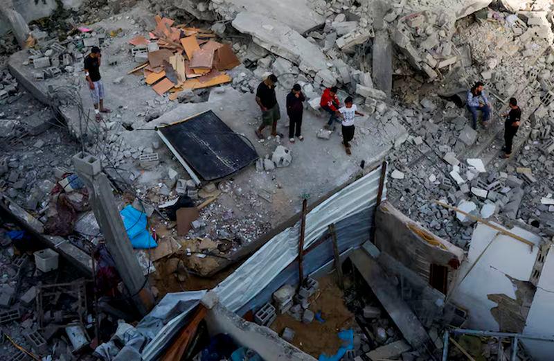 Palestinians inspect the site of an Israeli strike on a house, in Khan Younis in the southern Gaza Strip, May 3, 2025. REUTERS/Hatem Khaled