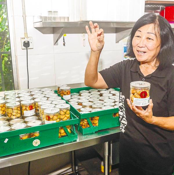 Leong showing the cookies packed in containers. About 30 to 50 boxes are exported to Hong Kong each week. – theSunpix
