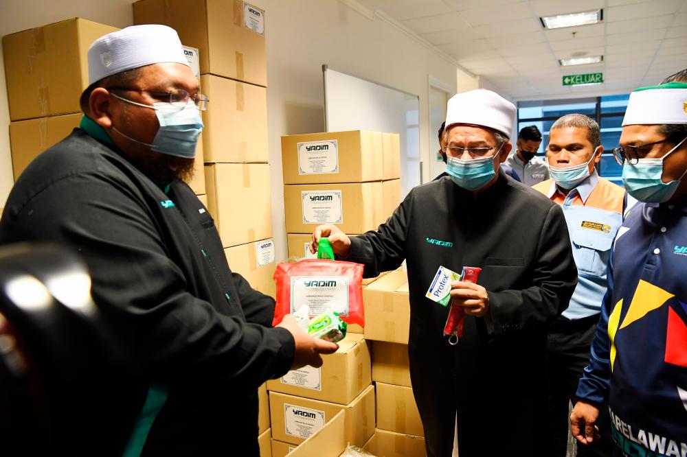 Minister in the Prime Minister’s Department (Religious Affairs) Datuk Seri Dr Zulkifli Mohamad Al-Bakri (middle) handing over contribution during the launch of the Yadim Flood Disaster Operations Room which was set up to coordinate efforts to help victims affected by the disaster. — Bernama