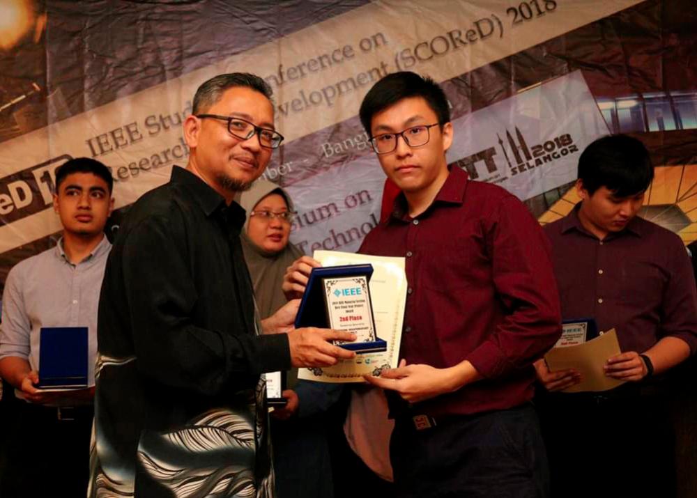 Yap receives the first runner-up award from an IEEE representative.