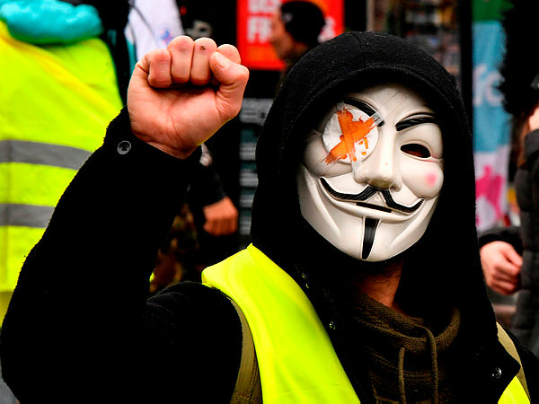 A “Yellow Vest” (Gilet Jaune) supporter wears a Guy Fawkes mask with a bandaged eye representing those protesters injured in the eye by “defensive ball launcher” (LBD) which are used by the French police, as he takes part in a ‘Day of strikes’ called by the France’s General Confederation of Labour (CGT) French worker’s union in the southwestern city of Bordeaux — AFP