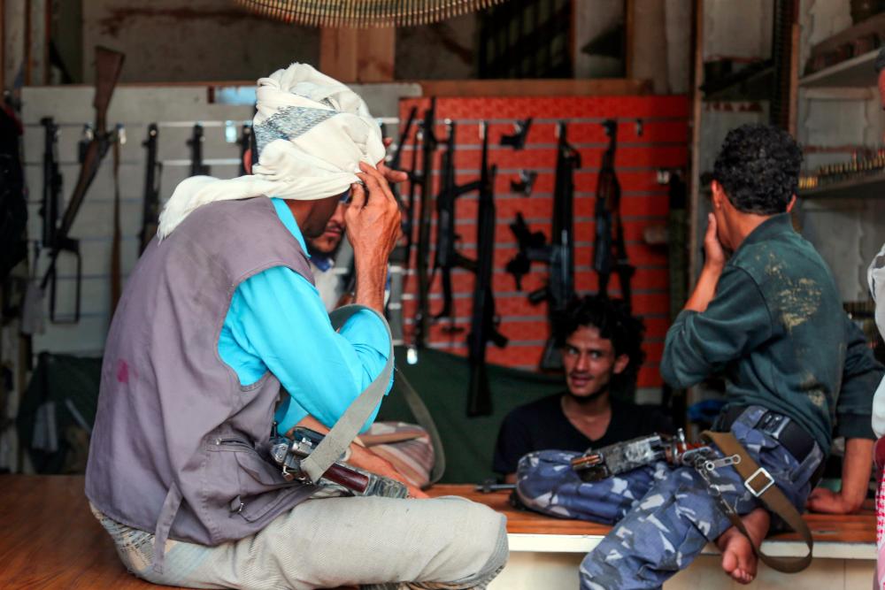 Armed men shop in Yemen’s third city of Taez, on July 13, 2019. — AFP