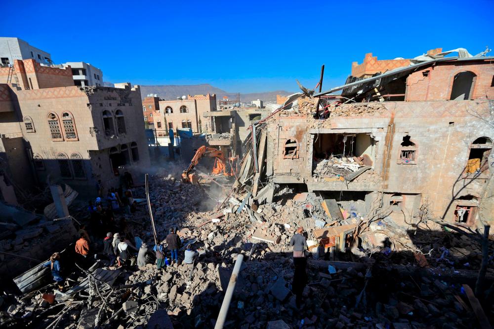 Yemenis inspect the damage following overnight air strikes by the Saudi-led coalition targeting the Huthi rebel-held capital Sanaa, on January 18, 2022. AFPPIX