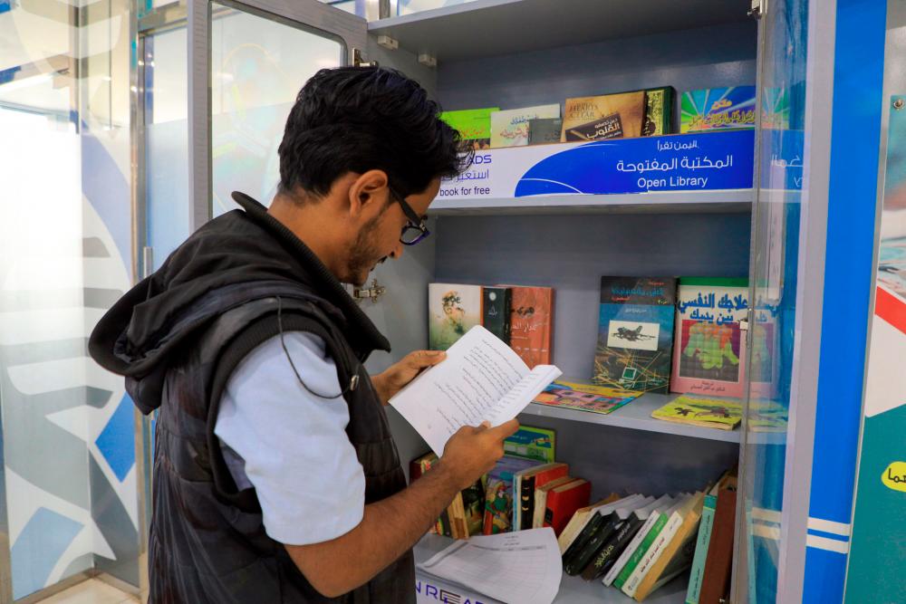 $!A Yemeni man checks out a book from a mini-library, put in place by “Yemen Reads” campaign, in the capital Sanaa on September 29, 2020. / AFP / Mohammed HUWAIS