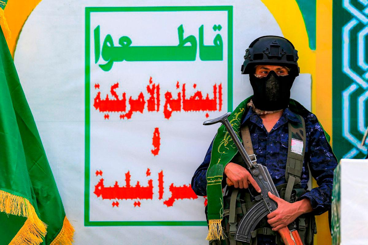For representational purposes only: A member of security forces loyal to Yemen’s Huthis stands guard by banner depicting their slogan urging a boycott of all US and Israeli goods, during an event at Sanaa University on the eve of the birthday of Islam’s Prophet Mohamed, in Sanaa on September 3, 2025. (Photo by Mohammed HUWAIS / AFP)