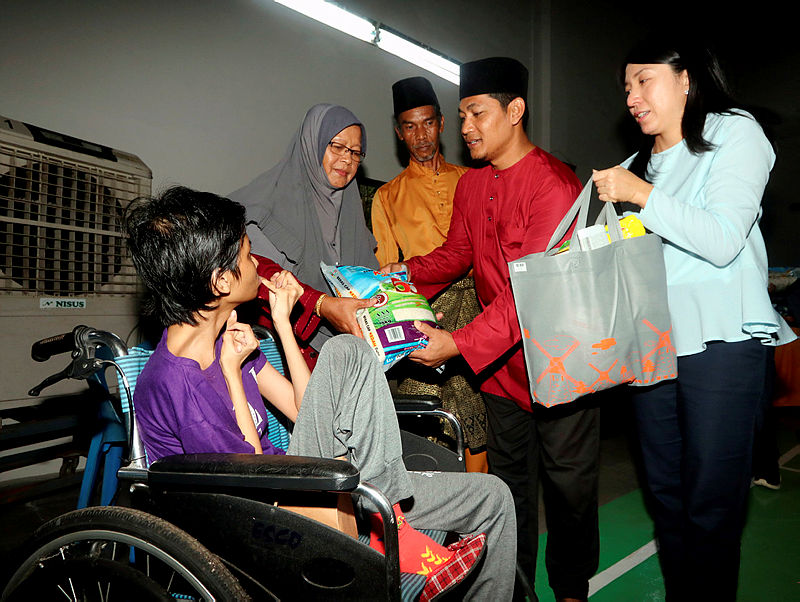 Minister of Energy, Science, Technology, Environment and Climate Change Yeo Bee Yin (R) and Bukit Naning assemblyman Md. Ysahrudin Kusni (2nd R), hand out aid to people with special needs during the Bakri parliamentary constituency breaking of fast event at the Seri Naning Hall, on May 12, 2019. — Bernama