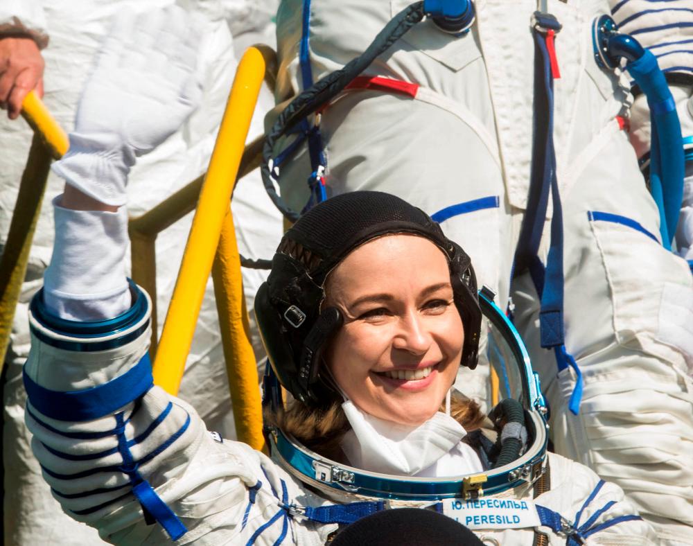 This handout photo taken and released on October 5, 2021 by Russian Space Agency Roscosmos shows Russian crew member, actress Yulia Peresild waving during the boarding to the Russia's Soyuz MS-19 spacecraft, before blasting off to the ISS from the launch pad at the Russian-leased Baikonur cosmodrome in Kazakhstan. AFPpix