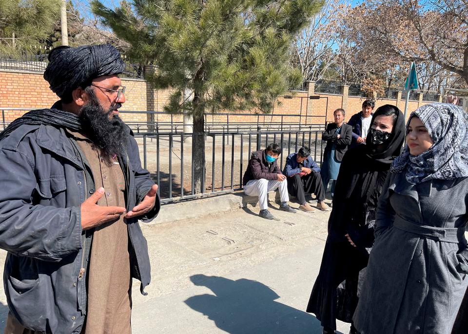 A member of Taliban speaks with female students outside the Kabul Education University in Kabul, Afghanistan, February 26, 2022. REUTERSpix