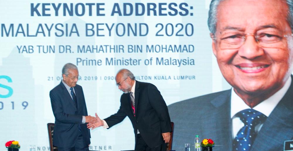 Prime Minister Tun Dr Mahathir Mohamad shakes hand with Chairman and Chief Executive of Institute of Strategic and International Studies (Isis) Tan Sri Rastam Mohd Isa (R) during his Q&amp;A on Praxisis Conference 2019. — Sunpix by Zulkifli Ersal.
